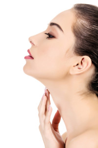 Side portrait of a beautiful woman with her hand touching her youthful neck